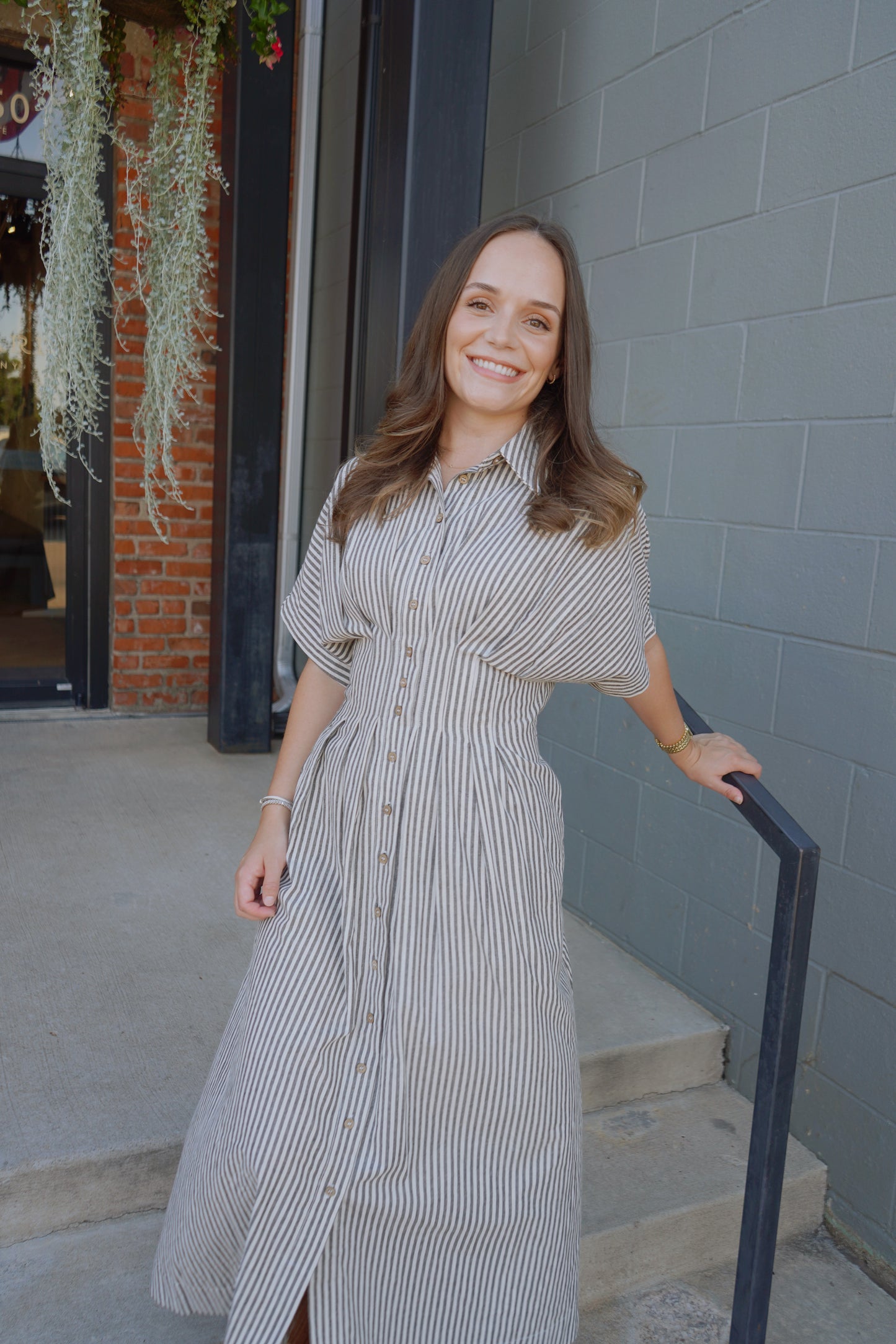Woman in a striped dress standing outside a building