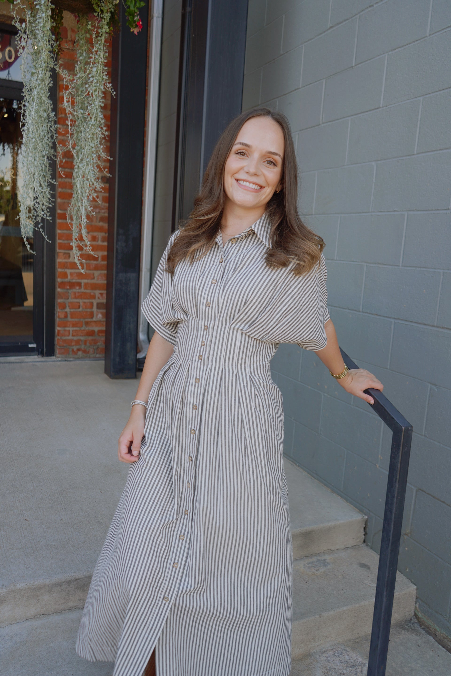 Woman in a striped dress standing outside a building